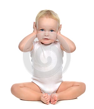 Infant child baby toddler sitting closed her hands over ears and