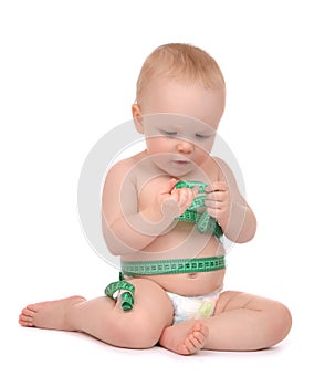 Infant child baby toddler sitting playing with tape measure meas