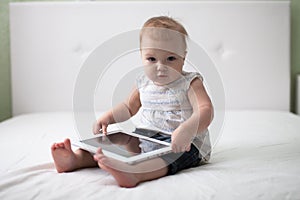 Infant child baby toddler sitting and typing digital tablet comp