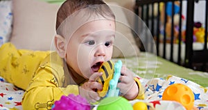 infant, childhood concept - close-up of smiling happy Baby plays with a teether. Teeth cutting. First teeth. Joy