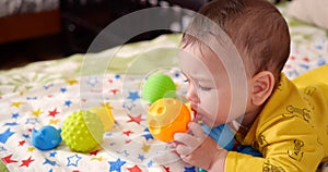 infant, childhood concept - close-up of smiling happy Baby plays with a teether. Teeth cutting. First teeth. Joy