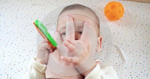 infant, childhood concept - close-up of smiling happy Baby plays with a teether. Teeth cutting. First teeth. Joy