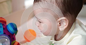 infant, childhood concept - close-up of smiling happy Baby plays with a teether. Teeth cutting. First teeth. Joy