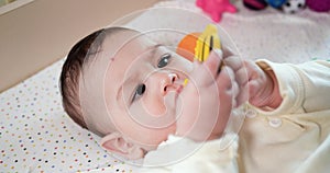 infant, childhood concept - close-up of smiling happy Baby plays with a teether. Teeth cutting. First teeth. Joy