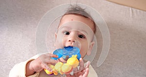 infant, childhood concept - close-up of smiling happy Baby plays with a teether. Teeth cutting. First teeth. Joy