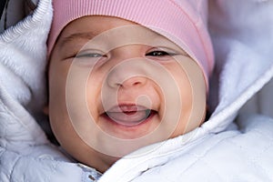 Infant, childhood, emotion concept - close-up of cute smiling portrait face of brown-eyed chubby newborn awake toothless