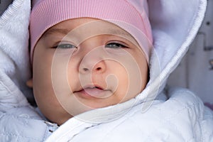 Infant, childhood, emotion concept - close-up of cute smiling portrait face of brown-eyed chubby newborn awake toothless