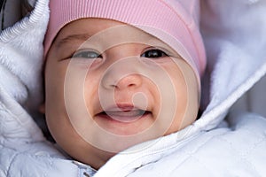 Infant, childhood, emotion concept - close-up of cute smiling portrait face of brown-eyed chubby newborn awake toothless