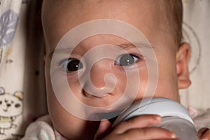 infant, childhood, emotion, food concept - close-up of smiling face of big brown-eyed chubby newborn awake baby 7 months