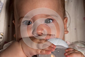 infant, childhood, emotion, food concept - close-up of smiling face of big brown-eyed chubby newborn awake baby 7 months