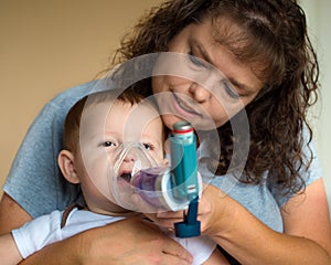 Infant getting breathing treatment from mother photo