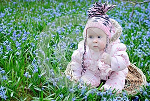 Infant girl sit snowdrops field