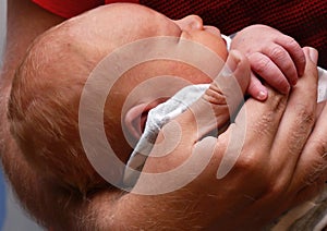 Infant holding father's hand