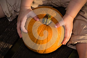 Infant Holding a Pumpkin