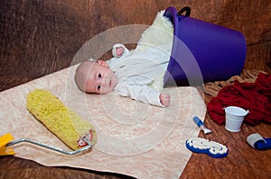 Infant laying on creative background with repairing tools