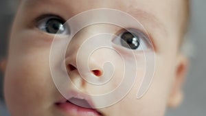 Infant lies on back with open big eyes