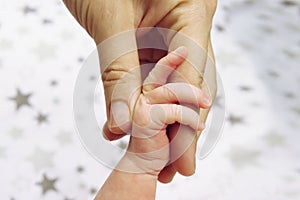 Infant, a newborn baby holding a mother`s finger closeup