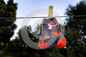 Infant\'s cute socks hanging on wire outdoors