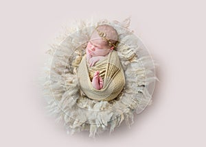 Infant sleeping swaddled with rabbit toy, topview