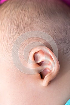 An infant small ear close-up showing skin texture.