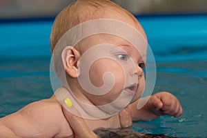 Infant swimming. Baby girl swimming in a pool.