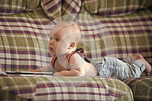 Infant wear jeans and suspenders at home