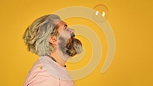 Infantility concept. Happy playful bearded hipster and soap bubbles. Happiness and joy. Good vibes. Blow inflate bubbles
