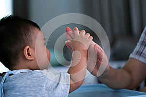 Infants are playing ball happily inside the house.