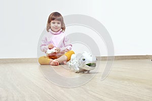 Infatuated cute little girl playing plastic toy lizard robot with a remote control. The nano-toy chameleon, modern technology of photo