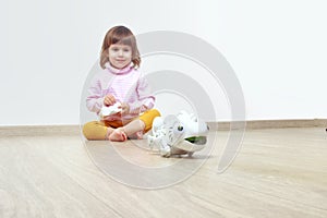 Infatuated cute little girl playing plastic toy lizard robot with a remote control. The nano-toy chameleon, modern technology of