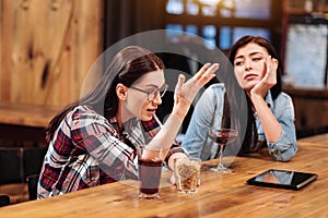 Infatuated with discussion girl holding glass with peanuts