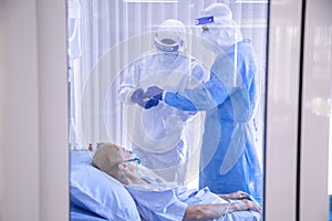 Infected patient lying on bed during takecare of Doctor and nurse with x-ray Lung in quarantine room