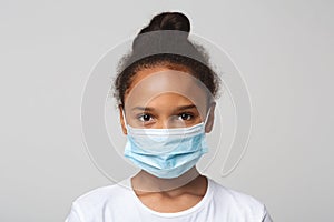 Portrait of little black girl wearing medical mask