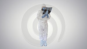 Infectious disease doctor in protective antibacterial suit and medical mask Pulmonologist examines an x-ray of lungs on