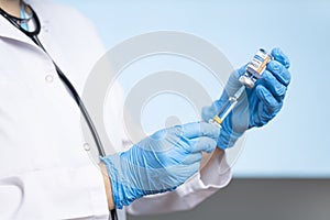 Infectious diseases doctor fills injection syringe with COVID-19 vaccine