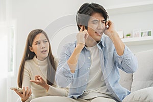 Infidelity, suspicion asian young couple love fight relationship, husband put hand on his ears, no want to hear. Wife anger