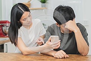 Infidelity, suspicion asian young couple love fight relationship, wife holding cellphone, smartphone cheating on phone, scolding