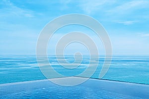 Infinity edge pool with blue sea and clear sky. Wide angle shot