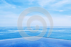 Infinity edge pool with blue sea and clear sky. Wide angle shot