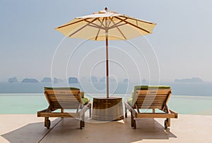 Infinity pool with parasol and sun beds at seaside