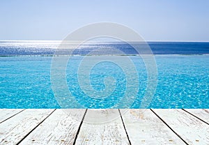 Infinity swimming pool and empty wooden plank