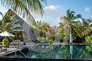 Infinity swimming pool near ocean and tropical beach view at island luxury resort