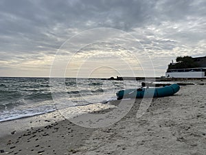 Inflatable boad on the beach on sunset