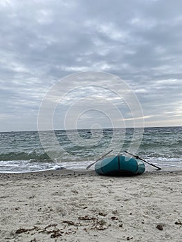 Inflatable boad on the beach on sunset