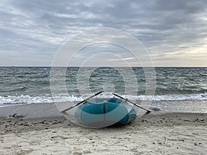 Inflatable boad on the beach on sunset