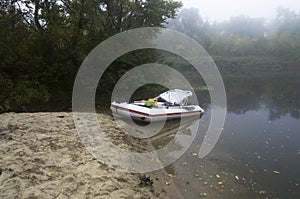 Inflatable boat on the bank of a misty river