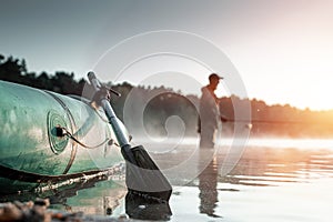 Inflatable boat on the lake at dawn, a fisherman at dawn fishing. Fishing hobby vacation concept. Copy space