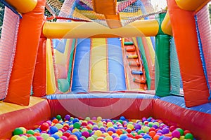 Inflatable castle full of colored balls for children to jump