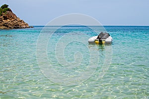 Inflatable dinghy boat with outboard motor moored in tropical sea