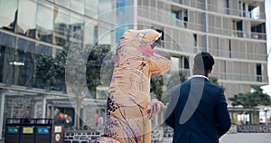 Inflatable dinosaur costume, man and outdoor for team building with tablet, handshake and mascot. Businessman, employee